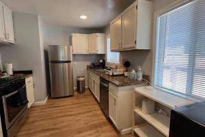 a kitchen with white cabinets and a stainless steel refrigerator at Cozy 2b/2b residential home in Berkeley in Berkeley