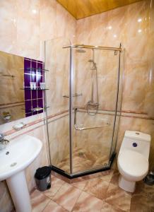 a bathroom with a shower and a toilet and a sink at Mia Casa Hotel Yerevan in Yerevan