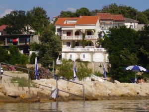 a house on the shore of a body of water at Apartments by the sea Lopar, Rab - 12534 in Lopar
