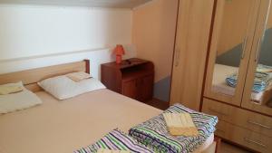 a bedroom with a bed and a dresser with a lamp at Apartments by the sea Lopar, Rab - 12534 in Lopar