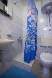 ein Bad mit einem WC und einem Duschvorhang in der Unterkunft Apartments with a parking space Baska Voda, Makarska - 12543 in Baška Voda