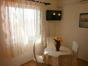ein Tisch und Stühle mit einer Blumenvase drauf in der Unterkunft Apartments with a parking space Baska Voda, Makarska - 12543 in Baška Voda