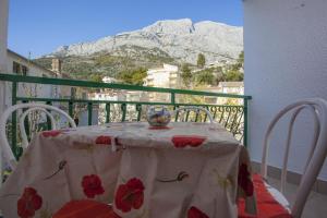 einen Tisch mit einer Vase auf einem Balkon mit einem Berg in der Unterkunft Apartments with a parking space Baska Voda, Makarska - 12543 in Baška Voda