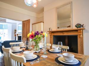 a dining room table with a vase of flowers on it at 55 Queen Street in Seaton