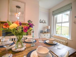 a dining room table with a vase of flowers on it at 55 Queen Street in Seaton +13 photos