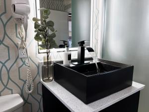 a bathroom with a black sink and a mirror at Oceanside Villas in Sechelt