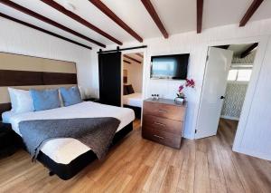 錫謝爾特的住宿－Oceanside Villas，一间卧室配有一张床和一台电视