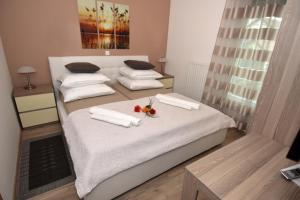 een slaapkamer met 2 bedden met witte lakens en bloemen bij Apartments with a parking space Zagreb - 12573 in Zagreb