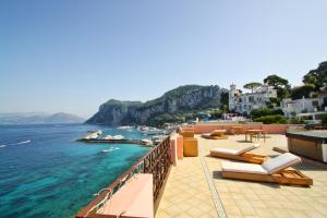e balcone con sedie a sdraio e vista sull'oceano. di Capri Inn a Capri