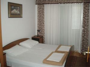 1 dormitorio con 1 cama blanca y ventana en Apartments with a parking space Slano, Dubrovnik - 12576 en Slano