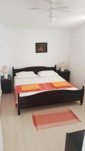ein Schlafzimmer mit einem großen Bett mit orangefarbener und orangefarbener Bettwäsche in der Unterkunft Apartments by the sea Viganj, Peljesac - 12564 in Kučište