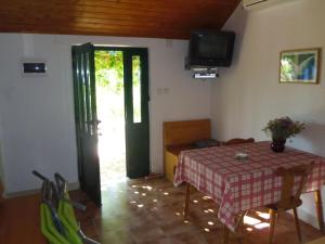 ein Esszimmer mit Tisch und Fernseher in der Unterkunft Holiday house with a parking space Bol, Brac - 12604 in Bol