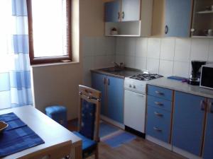 a kitchen with blue cabinets and a white stove top oven at Apartments with parking space Cres - 12609 in Cres