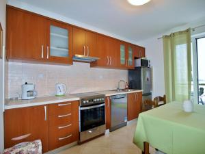 a kitchen with wooden cabinets and a table in it at Apartments and rooms by the sea Rab - 12616 in Rab