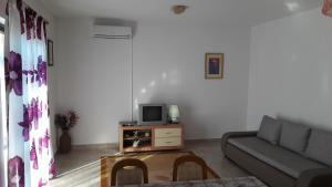 een woonkamer met een bank en een tv bij Apartments with a parking space Vinisce, Trogir - 12637 in Vinišće