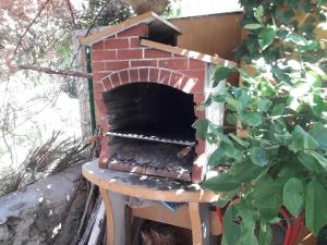 a brick oven sitting on a table next to a bush at Apartment Mali Losinj 12634a in Veli Lošinj