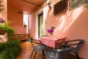 a table and chairs on a patio with a table and flowers at Apartment Mali Losinj 12634a in Veli Lošinj