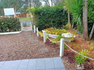 a garden with a fence and some plants at The Boathouse a 3 Bedroom House in Narooma