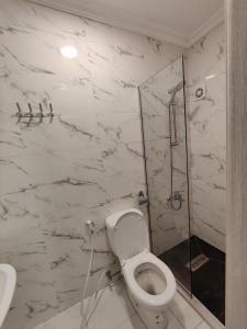 y baño blanco con aseo y ducha. en 44m luxury room near downtown and all services en Amán