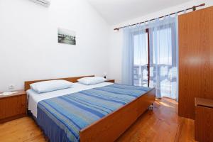a bedroom with a bed and a large window at Apartments by the sea Prizba, Korcula - 12648 in Prizba