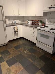 a kitchen with white appliances and a tile floor at BIG 3BR appartment at Olympic Stadium at PIE-IX Metro station in Montréal
