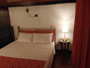 a bedroom with a bed and a lamp on a table at Los Lirios appartamento centro storico Ferrara in Ferrara