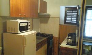a kitchen with a microwave on top of a refrigerator at Apartments with a parking space Smrika, Kraljevica - 12670 in Šmrika