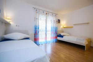 Un dormitorio con dos camas y una ventana. en Apartments with a parking space Ostrvica, Omis - 12674, en Gata