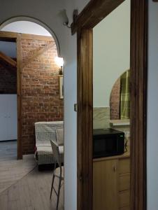 otwarte drzwi do kuchni z ceglaną ścianą w obiekcie Apartamenty nad Łyną w Olsztynie