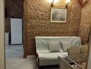 a living room with a brick wall and a couch at Apartamenty nad Łyną in Olsztyn