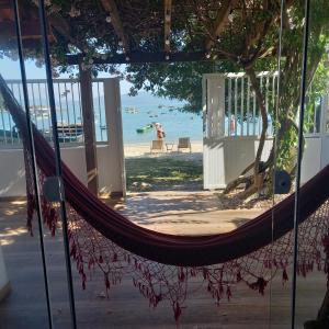 a hammock on a beach with the ocean in the background at Casa de praia Ponta dos Ganchos de Fora in Governador Celso Ramos