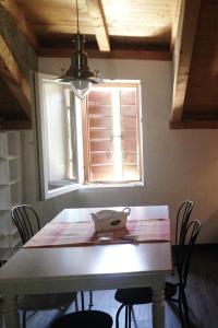 een eettafel met stoelen en een raam bij Apartments by the sea Cove Salbunara - Bisevo, Vis - 12700 in Komiža