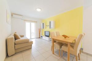 a living room with a dining room table and a couch at Apartments with a parking space Mandre, Pag - 12722 in Kolan