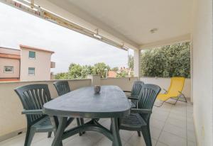 a patio with a table and chairs on a balcony at Apartments with a parking space Mandre, Pag - 12722 in Kolan