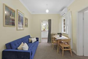 sala de estar con sofá azul y mesa en Katoomba Getaway en Katoomba