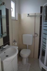 a bathroom with a white toilet and a sink at Apartments by the sea Biograd na Moru, Biograd - 12747 in Biograd na Moru