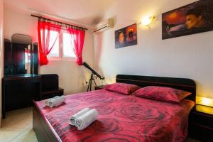 a bedroom with a red bed with two towels on it at Apartments by the sea Biograd na Moru, Biograd - 12747 in Biograd na Moru