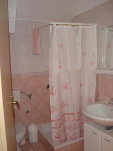 a bathroom with a shower curtain and a sink at Apartments by the sea Biograd na Moru, Biograd - 12747 in Biograd na Moru