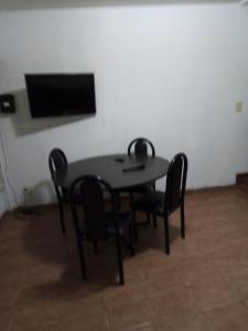 mesa y sillas en una habitación con TV en Departamento Mar de Plata 6 en Mar del Plata