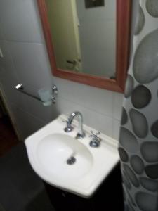 y baño con lavabo y espejo. en Departamento Mar de Plata 6 en Mar del Plata