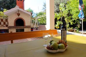 a bottle of wine and a bowl of fruit on a table at Apartments with parking space Seget Vranjica, Trogir - 12760 in Donji Seget