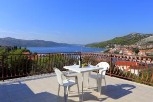 einen weißen Tisch und Stühle auf einem Balkon mit Aussicht in der Unterkunft Apartments with a parking space Seget Vranjica, Trogir - 12760 in Donji Seget