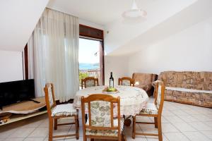 ein Wohnzimmer mit einem Tisch und einem Sofa in der Unterkunft Apartments with a parking space Seget Vranjica, Trogir - 12760 in Donji Seget