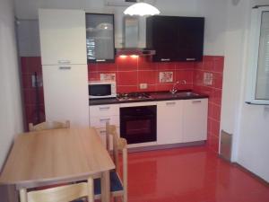 a kitchen with a wooden table and red tiles at Apartments by the sea Sumartin, Brac - 11658 in Sumartin