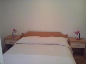 a bed with two nightstands with two lamps on them at Apartment Sumartin 11658b in Sumartin