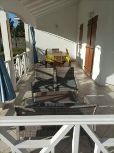 einen Balkon mit Stühlen und einem Tisch auf einem Gebäude in der Unterkunft Villa saisonnière Montalegre Lamentin in Lamentin