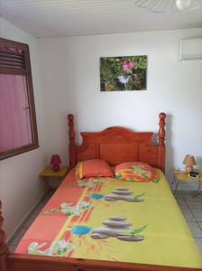 ein Schlafzimmer mit einem Bett mit einer farbenfrohen Tagesdecke in der Unterkunft Villa saisonnière Montalegre Lamentin in Lamentin