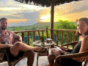 Un uomo e una donna seduti su una veranda di Shambala Paradise a Siquijor