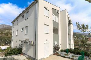 a white building with doors and windows at Apartments with a parking space Podstrana, Split - 12837 in Podstrana