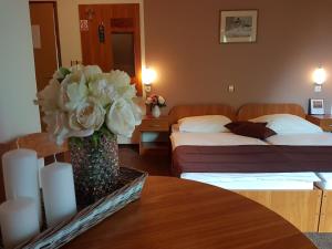 ein Hotelzimmer mit 2 Betten und einer Vase mit Blumen auf dem Tisch in der Unterkunft Rooms with a parking space Grabovac, Plitvice - 12835 in Rakovica